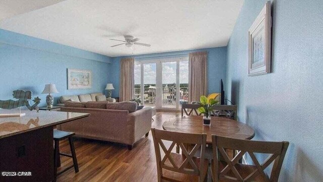 living room featuring ceiling fan and dark wood-type flooring