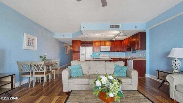 living room featuring dark hardwood / wood-style flooring, rail lighting, and ceiling fan