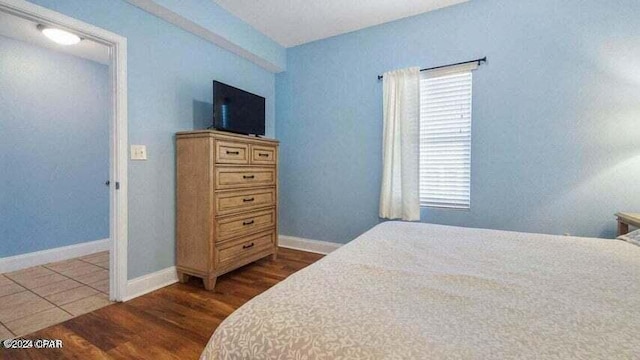 bedroom with dark wood-type flooring