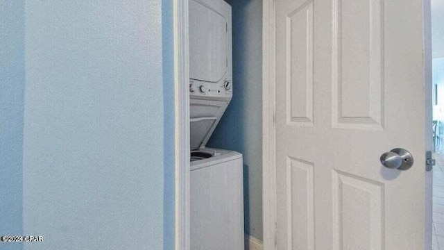 clothes washing area featuring stacked washer and clothes dryer