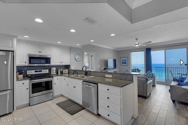 kitchen featuring ceiling fan, white cabinets, sink, kitchen peninsula, and stainless steel appliances