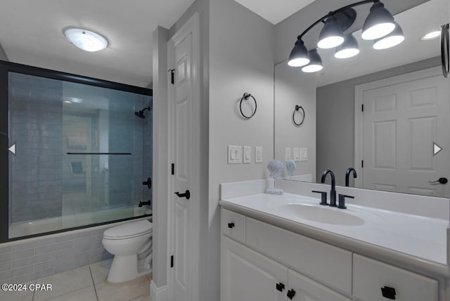 full bathroom featuring vanity, a chandelier, bath / shower combo with glass door, tile patterned floors, and toilet