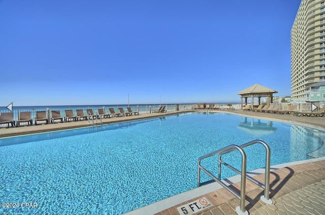 view of swimming pool with a water view and a gazebo