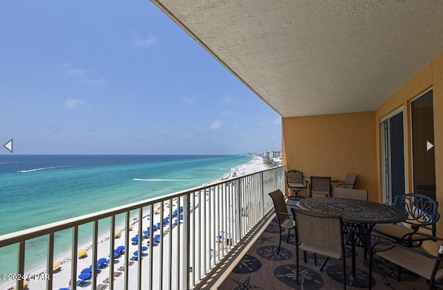 balcony featuring a water view and a view of the beach