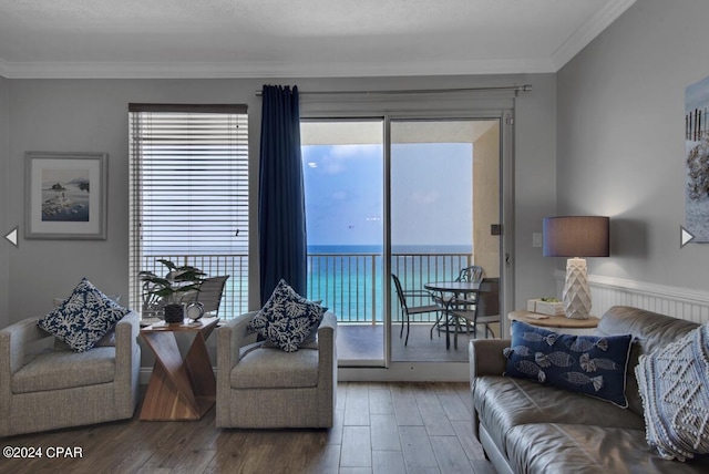 living room with wood-type flooring, crown molding, and a water view