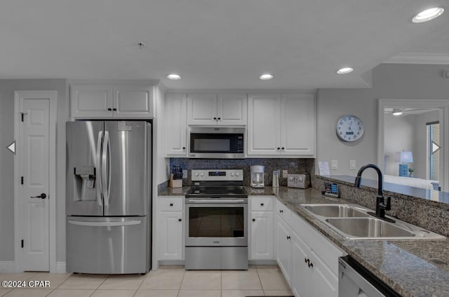 kitchen with light tile patterned flooring, sink, white cabinetry, backsplash, and appliances with stainless steel finishes