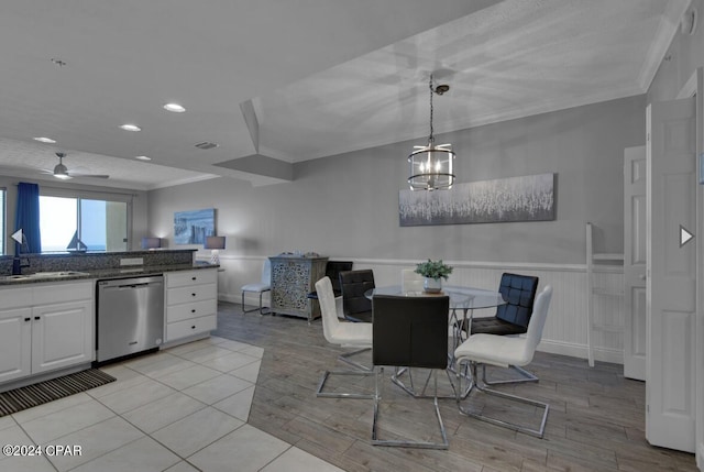 dining area with ceiling fan with notable chandelier, light hardwood / wood-style floors, ornamental molding, and sink