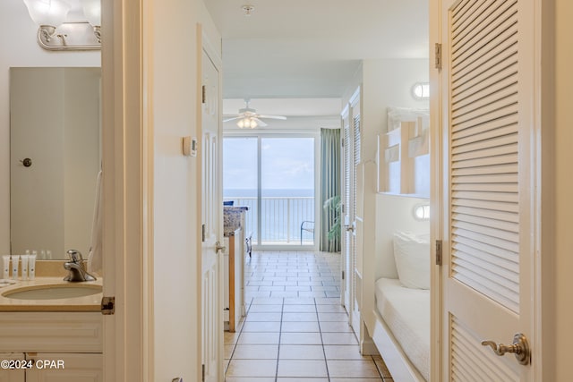 hall featuring light tile patterned floors and sink