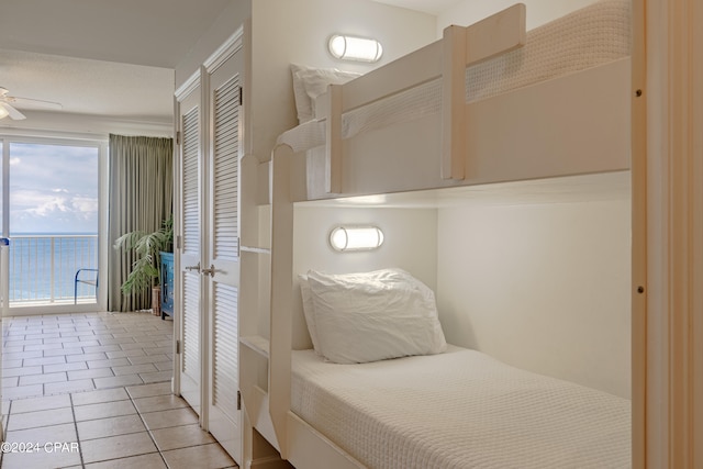 bedroom with ceiling fan and light tile patterned floors