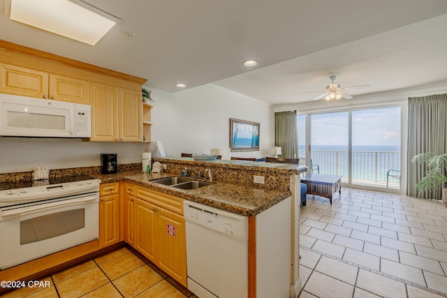 kitchen with white appliances, kitchen peninsula, sink, ceiling fan, and light tile patterned flooring