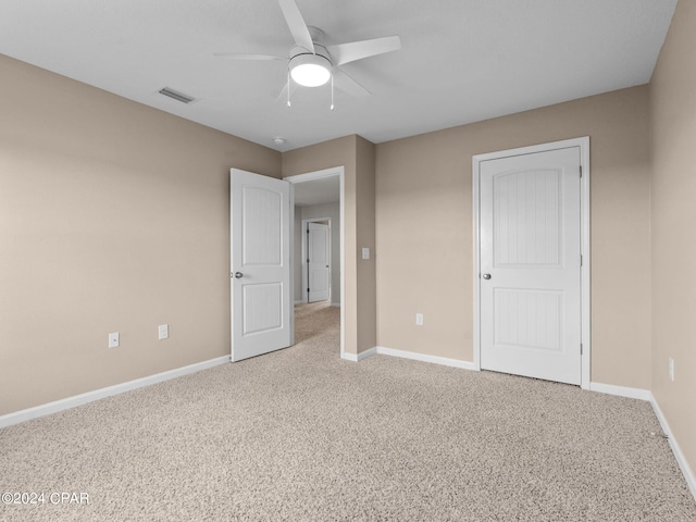 unfurnished bedroom with ceiling fan and light carpet