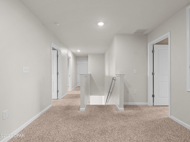 hall with light colored carpet