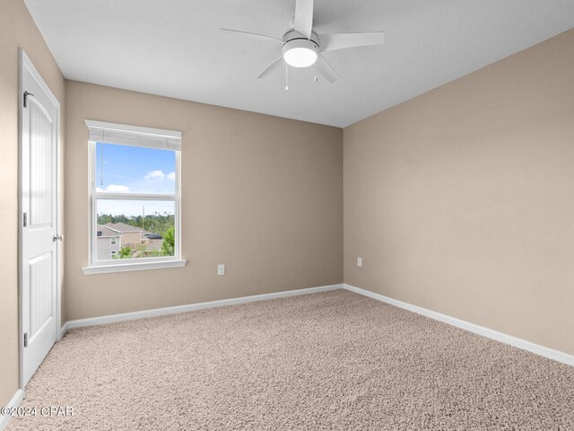 carpeted empty room featuring ceiling fan