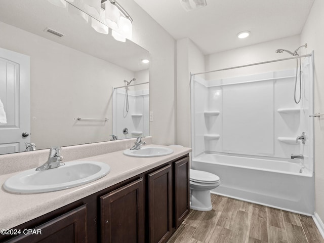 full bathroom featuring toilet, hardwood / wood-style flooring, shower / washtub combination, and vanity