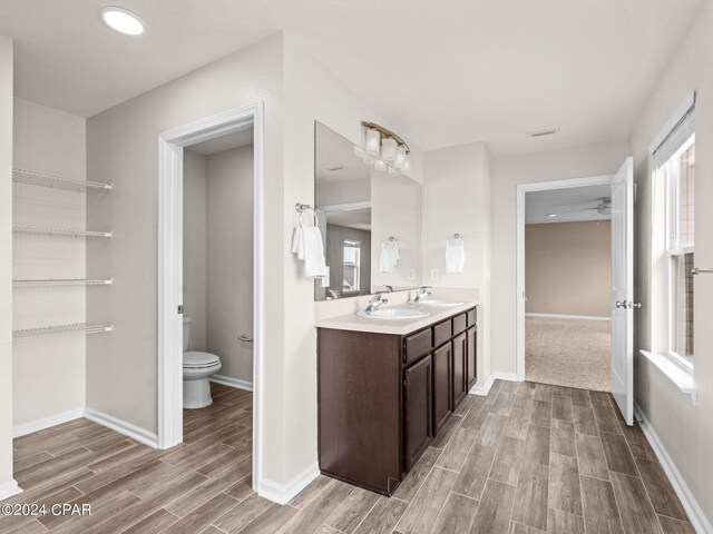 bathroom with vanity, toilet, and ceiling fan