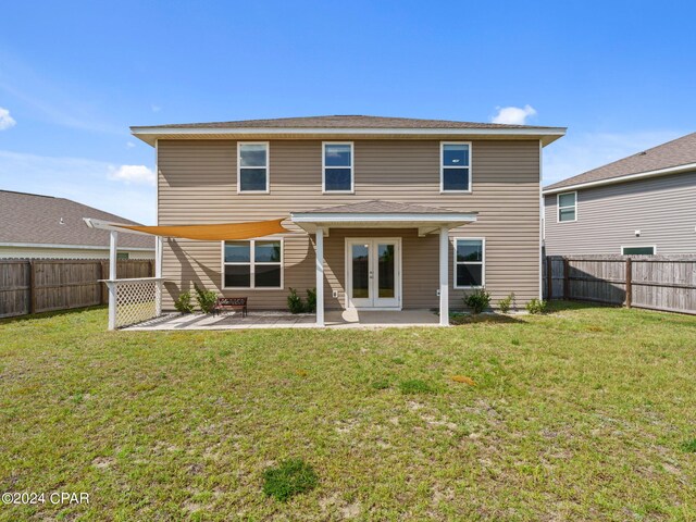 rear view of property featuring a lawn and a patio