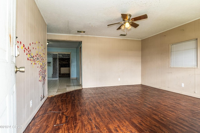 empty room with a textured ceiling, dark hardwood / wood-style floors, and ceiling fan