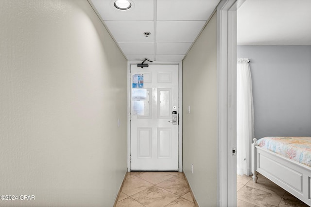 interior space featuring a paneled ceiling and light tile patterned floors