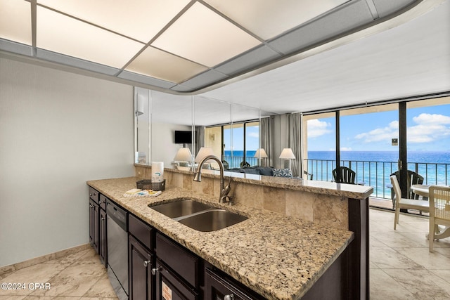 kitchen with sink, a wealth of natural light, and light stone countertops