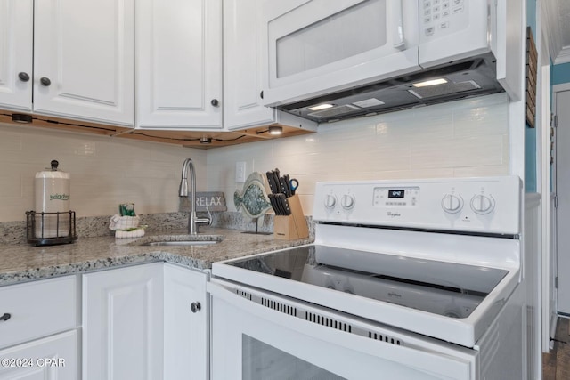 kitchen featuring light stone counters, white cabinets, sink, white appliances, and backsplash