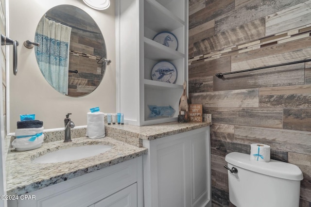 bathroom featuring wood walls, a shower with curtain, vanity, and toilet