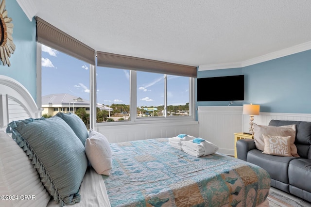 bedroom with ornamental molding, a textured ceiling, and hardwood / wood-style flooring