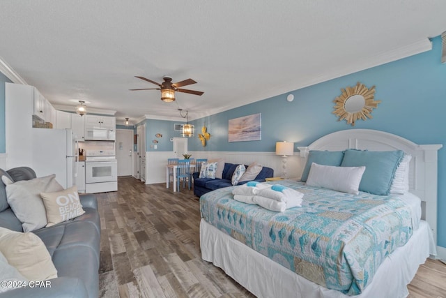 bedroom featuring white fridge, a textured ceiling, ceiling fan, ornamental molding, and hardwood / wood-style floors