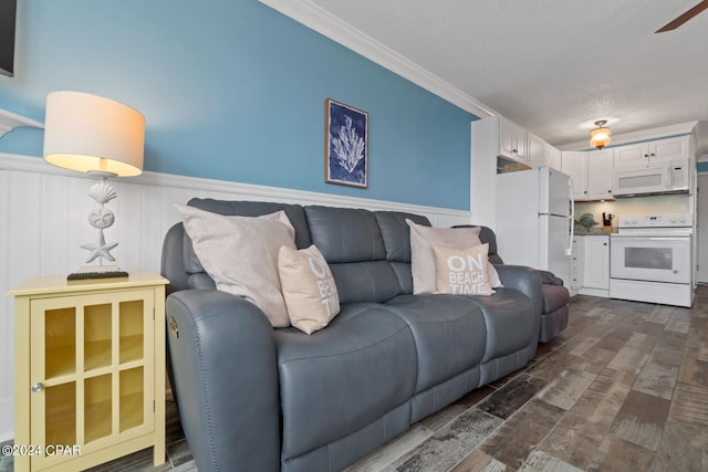 living room with ceiling fan, crown molding, and a textured ceiling