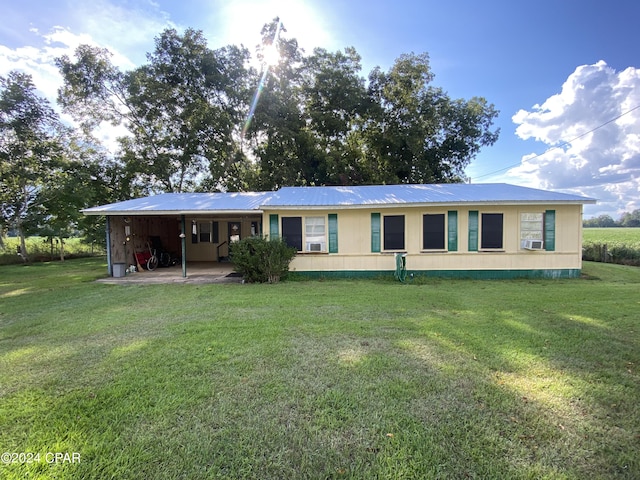 view of front of home with metal roof, a front yard, and cooling unit