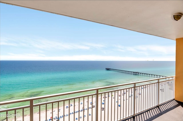 balcony featuring a view of the beach and a water view