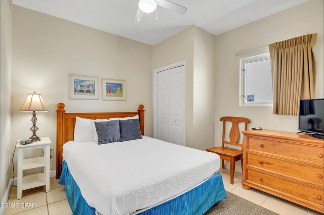 bedroom with light tile patterned floors, a closet, and ceiling fan