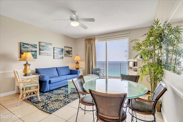 living room with ceiling fan, light tile patterned floors, and a water view