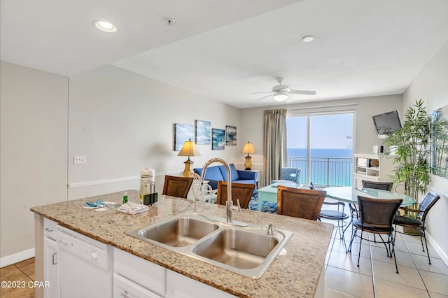 kitchen with white cabinets, dishwasher, light tile patterned floors, ceiling fan, and a kitchen island with sink