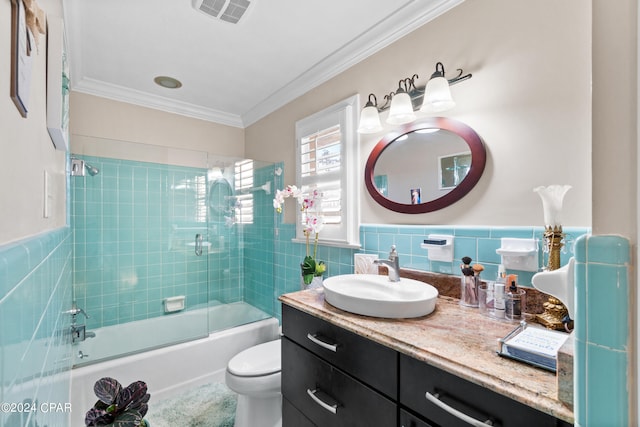 full bathroom featuring enclosed tub / shower combo, vanity, tile walls, crown molding, and toilet