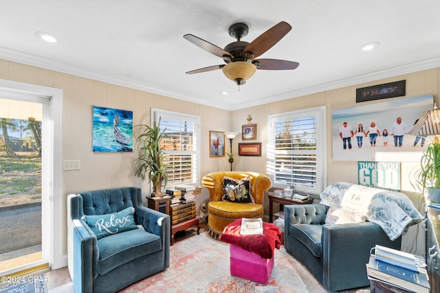 living area with a healthy amount of sunlight, ornamental molding, ceiling fan, and hardwood / wood-style flooring