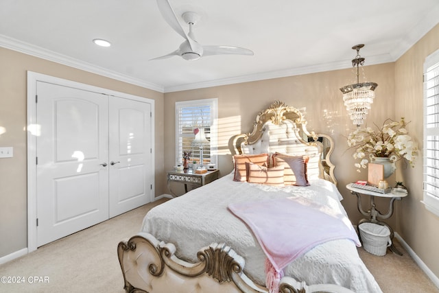 bedroom with ceiling fan with notable chandelier, crown molding, light colored carpet, and a closet