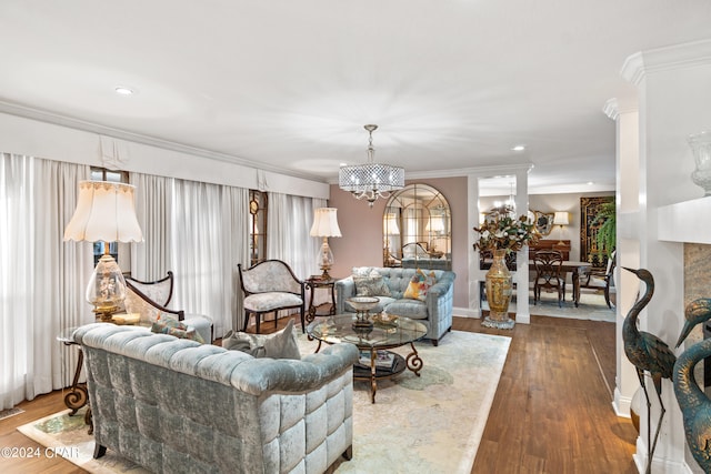 living room with a chandelier, hardwood / wood-style floors, and crown molding