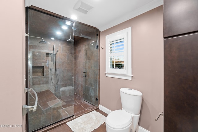 bathroom featuring a shower with shower door, toilet, and crown molding