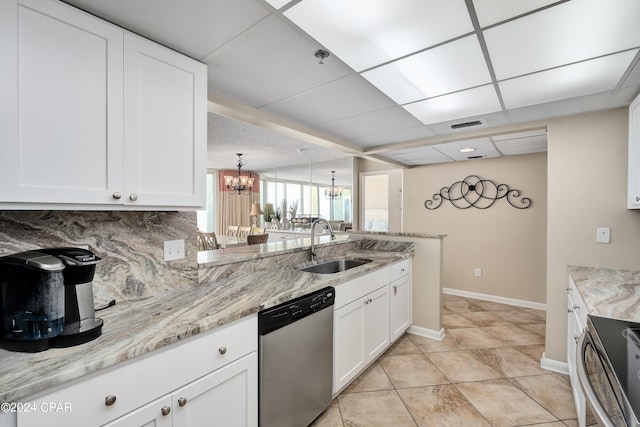 kitchen featuring appliances with stainless steel finishes, white cabinetry, and an inviting chandelier