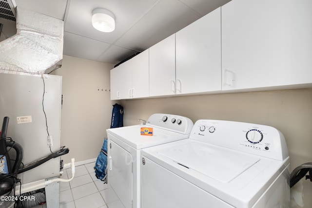 washroom with light tile patterned floors, independent washer and dryer, and cabinets