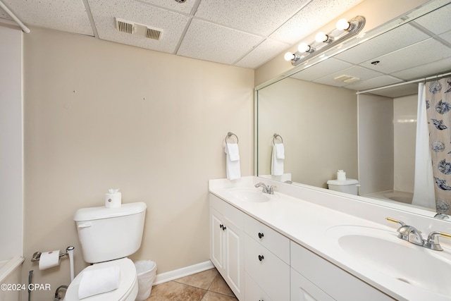 bathroom featuring vanity, a drop ceiling, tile patterned floors, toilet, and a shower with shower curtain