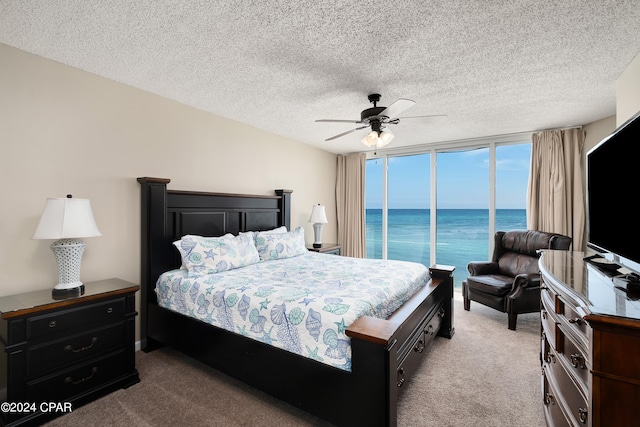 bedroom featuring light carpet, ceiling fan, access to exterior, and a textured ceiling