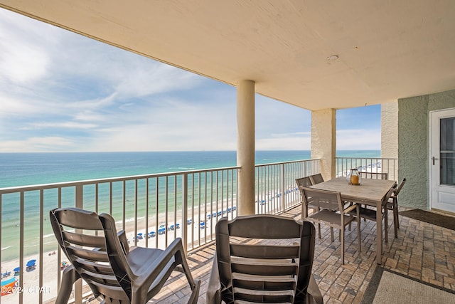 balcony featuring a view of the beach and a water view