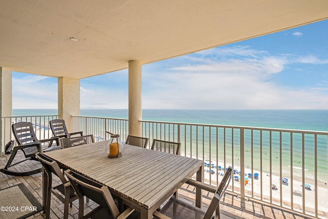 balcony featuring a view of the beach and a water view