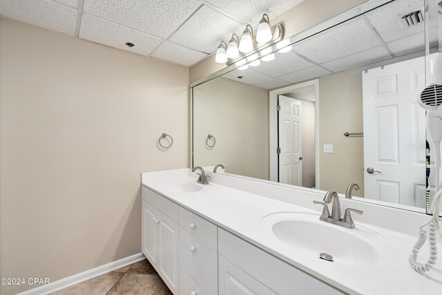 bathroom featuring a paneled ceiling, tile patterned flooring, and vanity