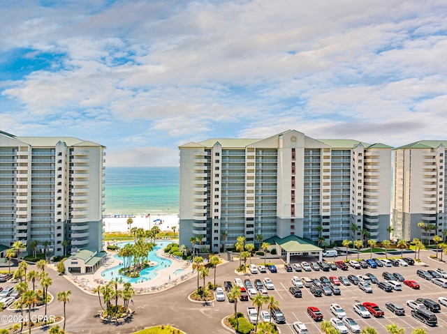 view of building exterior featuring a water view and a view of the beach