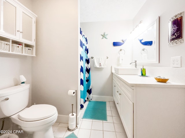 bathroom featuring tile patterned flooring, a textured ceiling, vanity, and toilet