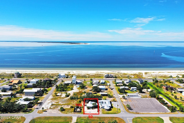 birds eye view of property featuring a water view and a beach view