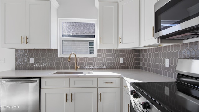 kitchen featuring white cabinetry, appliances with stainless steel finishes, sink, and backsplash