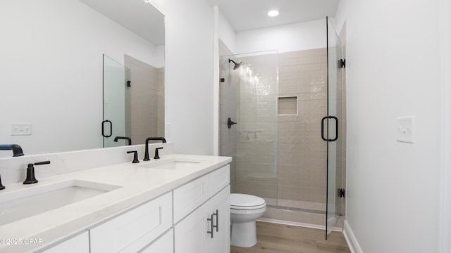 bathroom with walk in shower, vanity, toilet, and hardwood / wood-style floors